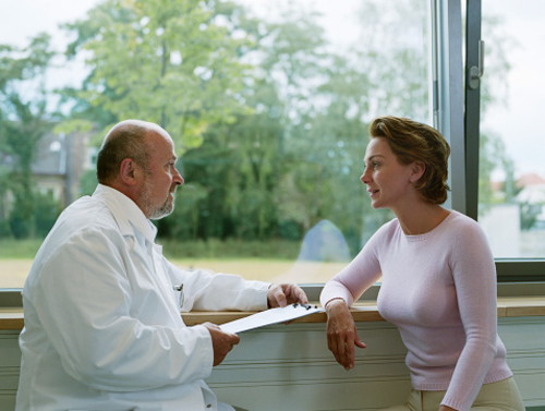 A cardiologist explaining how to order an echocardiogram or carotid ultrasound, step by step to a patient.